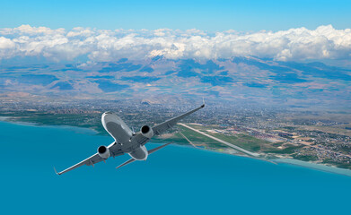 Airplane taking off from airport - Passenger airplane is flying over amazing mountains and sea  - Travel by air transport