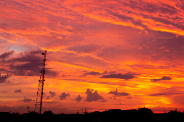 Mobile communication tower during sunset with a red sky on background. Wireless, 5G, mobile concept.