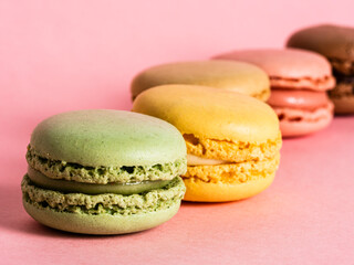 Delicious colorful macarons on pink background