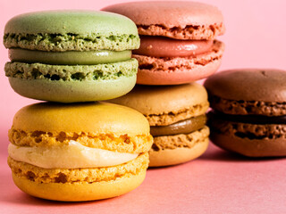 Delicious colorful macarons on pink background