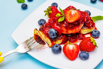 Cottage cheese pancakes with fresh berries and strawberry sauce. Healthy breakfast concept for kids
