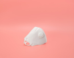 Medical respirator on a pink background. Surgical mask with filter. The prevention and protection against viruses. Coronavirus, covid-19 concept.