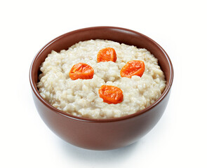 oatmeal with dried apricots in ceramic bowl isolated white background