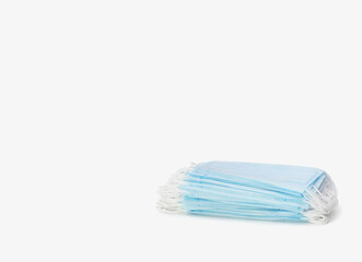 A stack of blue medical masks on a white background. Protection and prevention against coronavirus, covid-19 and other viruses. Healthcare and medical concept.