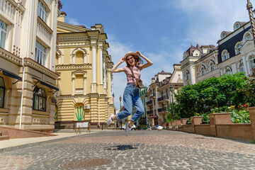 Obraz premium Beautiful Young Woman tourist walking and jumping in the City Center