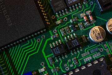 Macro close-up shot of green circuit board, computer motherboard Components: microcircuits, processor, transistors, semiconductors. Inside an electronic device, parts of a supercomputer.