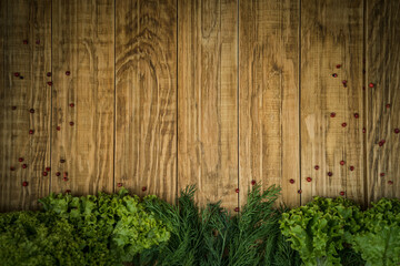 Food background. Eggplant, green salad, herbs, peppercorns on a wooden background.