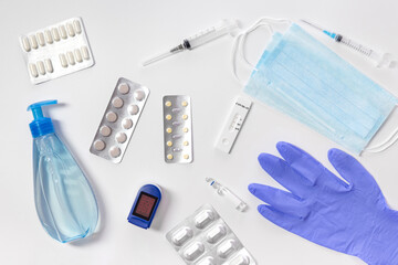 A set of various medical items. Gloves, syringe, mask, tablets and sanitizer, test on a white background. Means for the prevention and treatment of coronavirus.