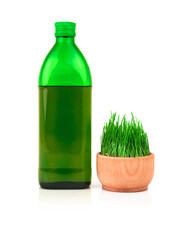 Glass green bottle and sprouts of wheat in wooden bowl isolated