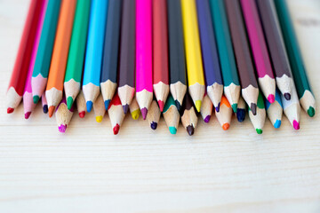 Close up multicolored pencils isolated on wooden background with copy space. Colored wooden crayons. Concept of art