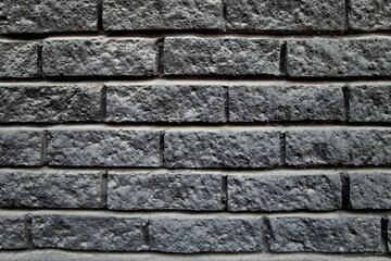 Grey brick wall texture background close up with copy space. Selective focus