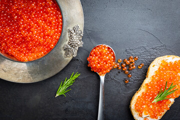 Delicious red caviar in vintage plate, top view, dark background