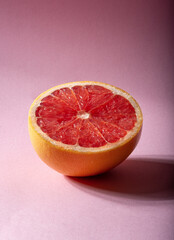 Ripe juicy grapefruit on a pink background