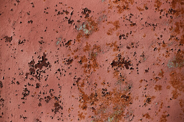 Structured surface of aged red rusty wall with peeling paint
