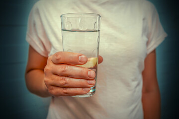 Womans hand holding a glass of water. Close-up of a glass. Closeup of female's hand holding glass of water. Refreshment and detox concept. Nutrition concept