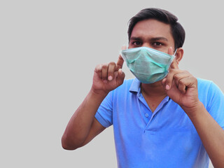 Young man in blue T-Shirt wears face mask for corona outbreak spread protection.