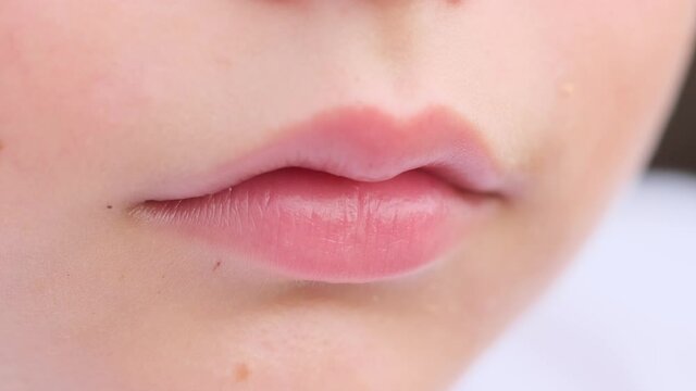 Closeup view of cute pink lips of young caucasian child. Macro.