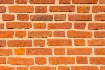 Reddish brick wall close up for background in natural summer light