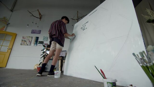 moustache artist drawing reduce sign on big white canvas