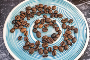 Coffee beans on a blue saucer close up. Coffee concept