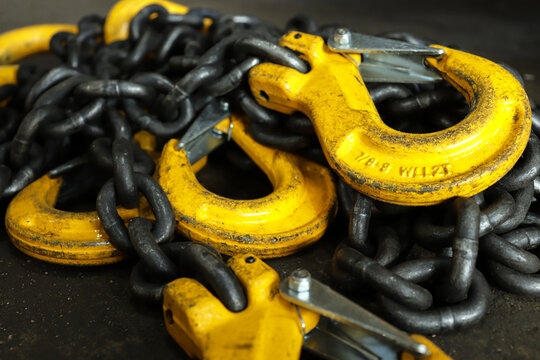 Iron chains with hooks lie on the floor of the workshop. A device for loading and unloading goods.