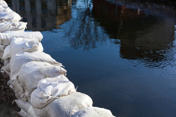 Sandbag dam to protect against overflowing water Technical aid organization accident catastrophe flooding port city water damage safety precaution fix dam in disaster