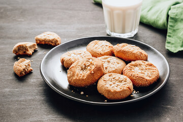 Gluten free homemade oatmeal cookies and oat milk on a dark background.