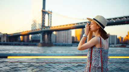 Young woman with a retro camera at the Manhattan Bridge