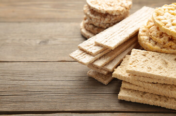 Various types of healthy whole grain crispbreads with copy space on grey wooden background.