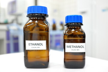 Selective focus of ethanol and methanol brown amber glass bottle inside a laboratory. Blurred...