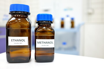 Selective focus of ethanol and methanol brown amber glass bottle inside a laboratory. Blurred...