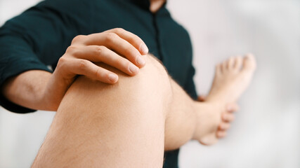 Young man having his knee examined by specialist. Physiotherapy knee flexibility. High quality photo