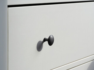 Part of a white modern wooden chest of drawers