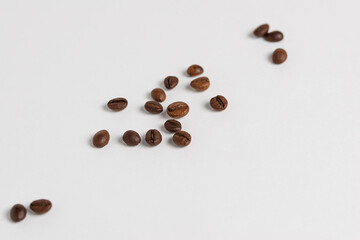 macro photo of roasted coffee beans scattered on a white background