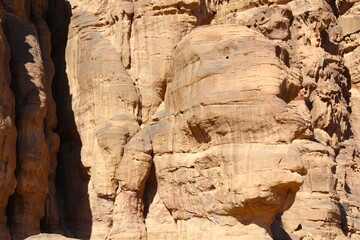 Deserted landscape view of the Wadi Rum desert, close-up of a rock cliff,  mountain and dunes, orange and red, Jordan.