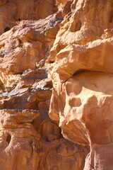 Deserted landscape view of the Wadi Rum desert, close-up of a rock cliff,  mountain and dunes, orange and red, Jordan.