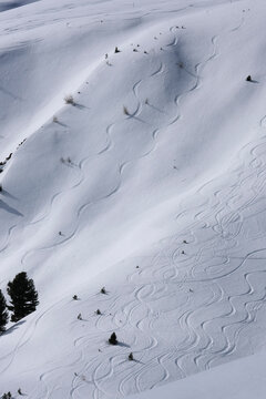 Skiers winding down sunny mountain ski slope, Davos, Switzerland