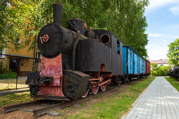 Old steam locomotives and cars on historic train station