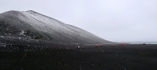 Antarctica, deception island, white snow on volcanic black mountain, snow storm