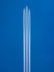 Three planes in formation in the blue sky with a condensation trails