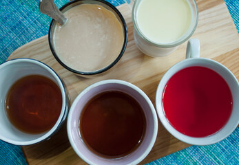 Cups with milk, compote, coffee, tea, flat lay