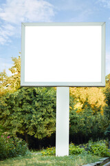 blank white billboard against blue sky. big board with park background.