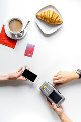 Plakat Coffee, croissant and card payment on white background top view