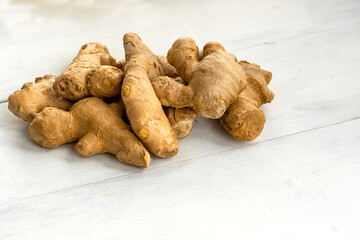 a bunch of ginger on a white wooden background