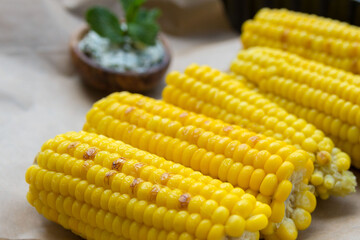 Young yellow sweet corn on the grill. Delicious summer meal. Closeup.