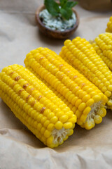 Young yellow sweet corn on the grill. Delicious summer meal. Vertical orientation.
