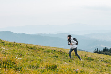 woman with backpack hiking in mountains