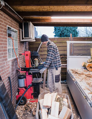 Man cutting firewood with wood splitter