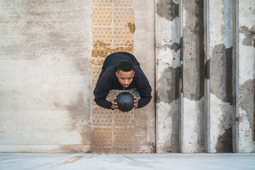 Athletic man doing wall ball exercise.