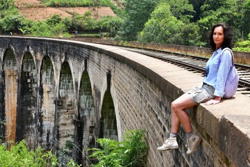 Woman enjoying a view over Nine Arches bridge in Demodara one of the iconic landmarks in Sri Lanka